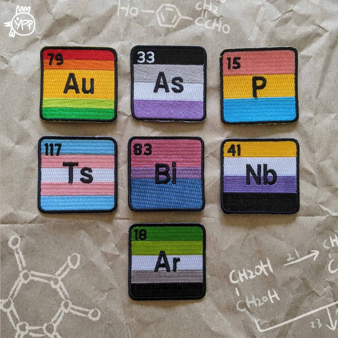 Periodic table patches with colorful elements on a textured surface with chemical drawings.