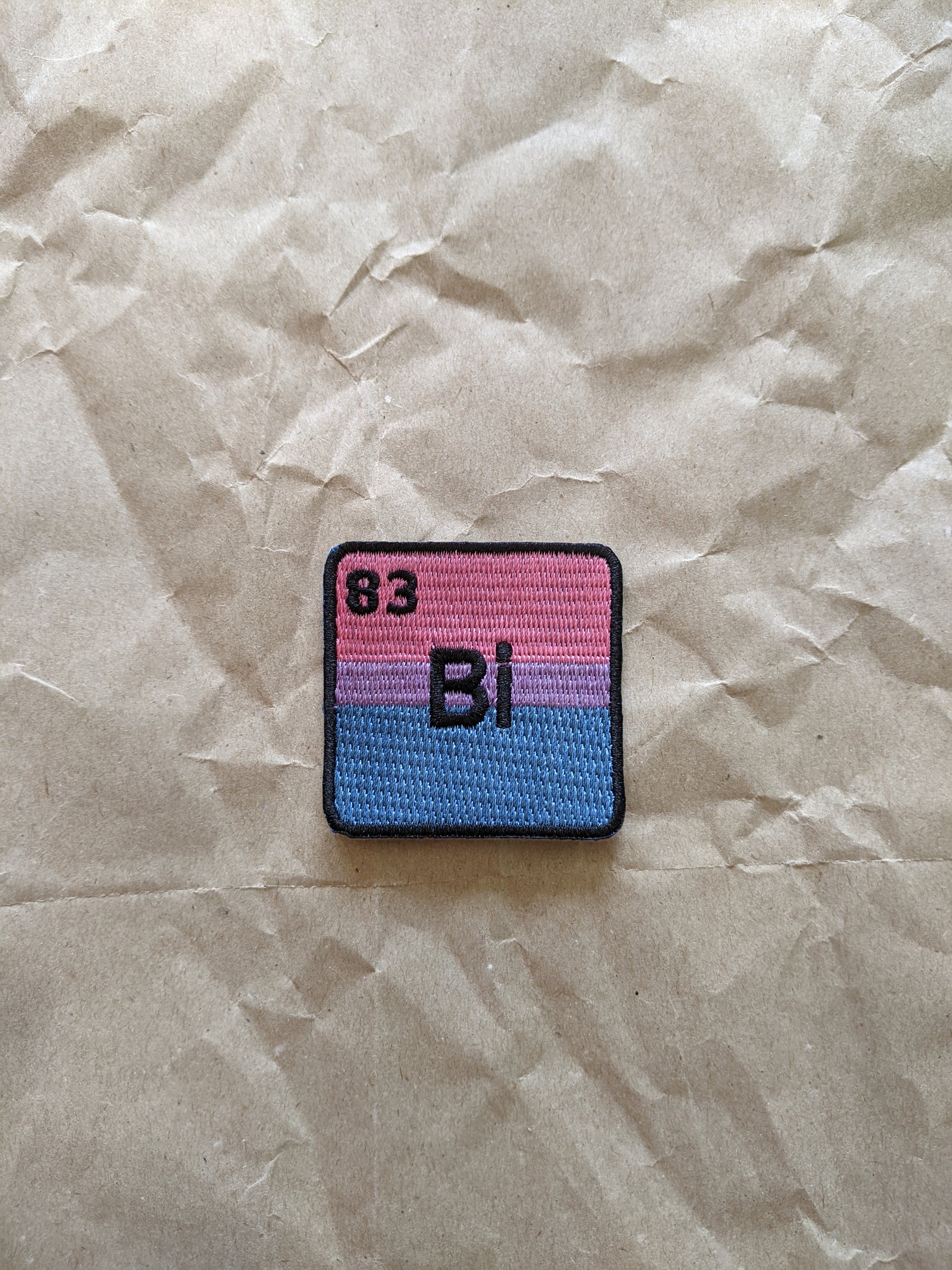 Patch with chemical element bismuth '83 Bi' on a crumpled paper background